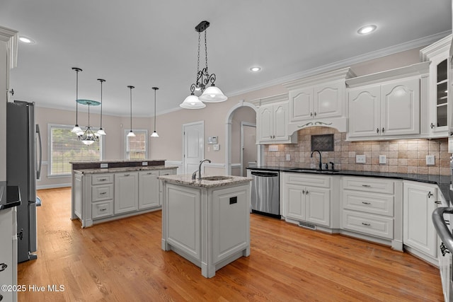 106 Cliffwell Dr, Goldsboro, NC 27530 - kitchen with stainless steel appliances, an island with sink, a sink, ornamental molding, and light wood-type flooring