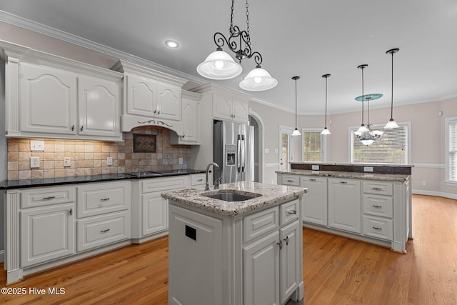106 Cliffwell Dr, Goldsboro, NC 27530 - kitchen with an island with sink, stainless steel fridge, a sink, light wood-style floors, and crown molding