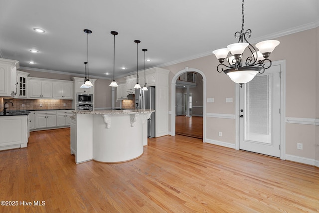 106 Cliffwell Dr, Goldsboro, NC 27530 - kitchen with appliances with stainless steel finishes, a sink, arched walkways, white cabinets, and backsplash