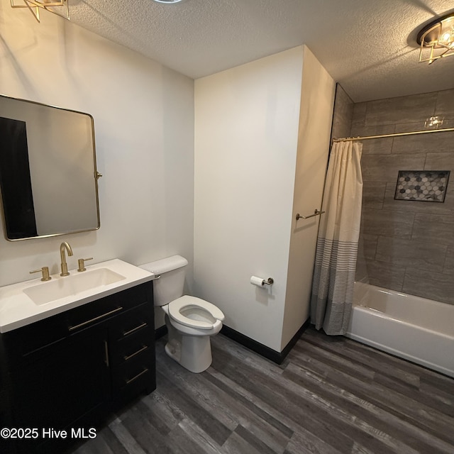 full bath featuring vanity, wood finished floors, shower / bath combination with curtain, toilet, and a textured ceiling