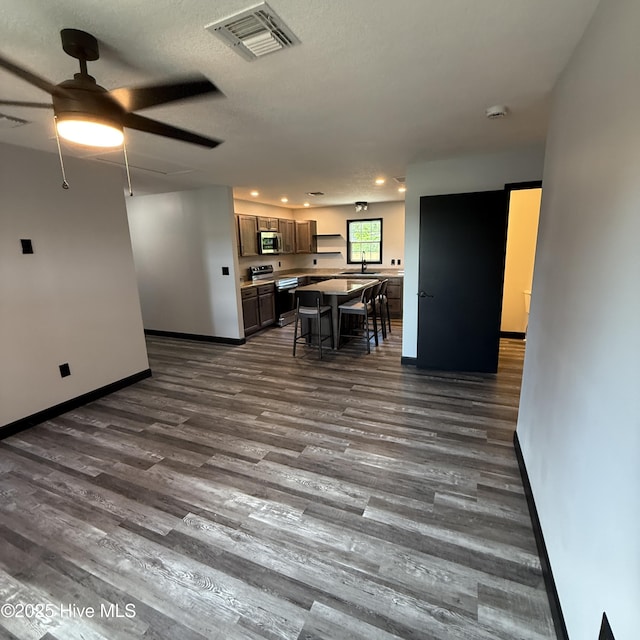 interior space with dark wood-style flooring, ceiling fan, recessed lighting, baseboards, and visible vents