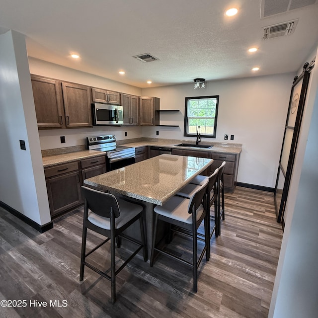 kitchen featuring a sink, baseboards, stainless steel appliances, and visible vents