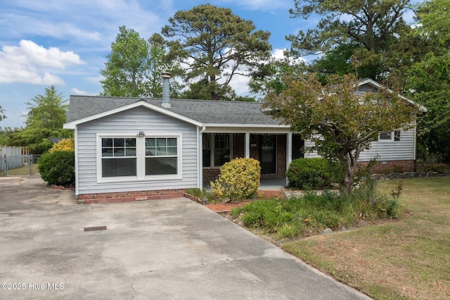 view of front of property with a porch, a shingled roof, and fence