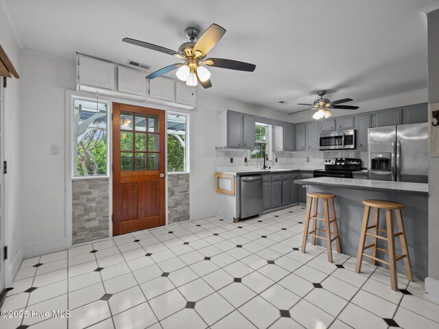 40 Eagle Rock Ln, Hubert, NC 28539 - kitchen with visible vents, a kitchen bar, gray cabinets, a ceiling fan, and stainless steel appliances