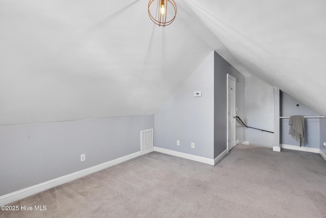 bonus room featuring lofted ceiling, carpet, and baseboards