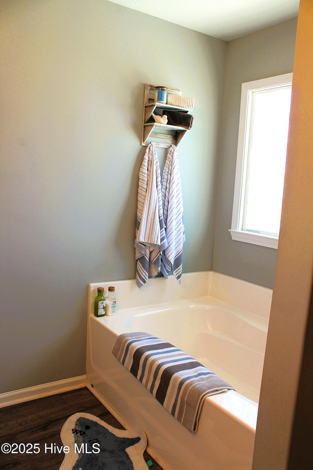 full bathroom featuring wood finished floors and a bath