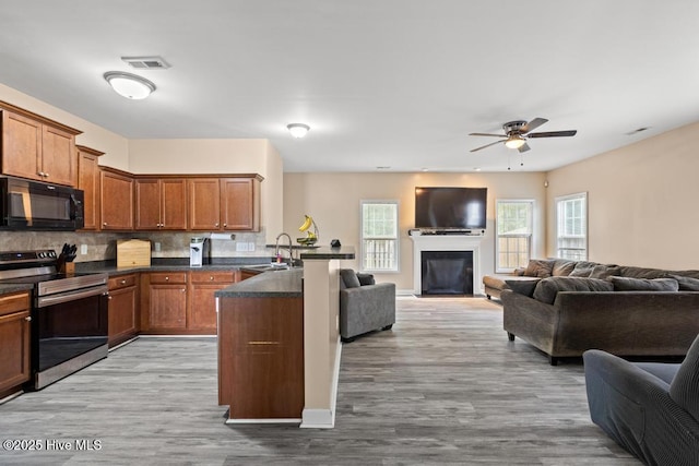248 Seville St, Jacksonville, NC 28546 - kitchen featuring black microwave, stainless steel electric range oven, open floor plan, a sink, and brown cabinetry
