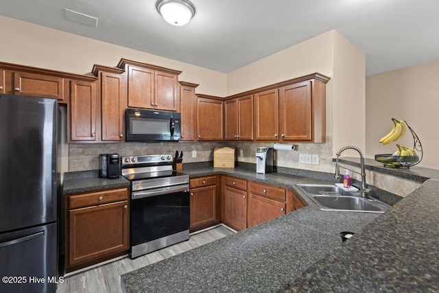 248 Seville St, Jacksonville, NC 28546 - kitchen featuring black appliances, a sink, light wood finished floors, and tasteful backsplash