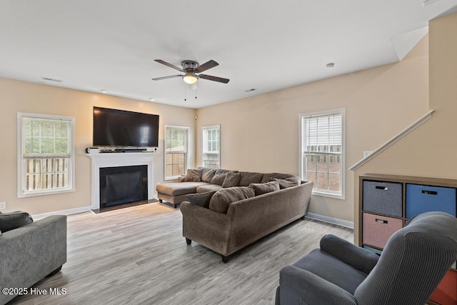 248 Seville St, Jacksonville, NC 28546 - living area featuring ceiling fan, wood finished floors, baseboards, a fireplace with flush hearth, and healthy amount of natural light