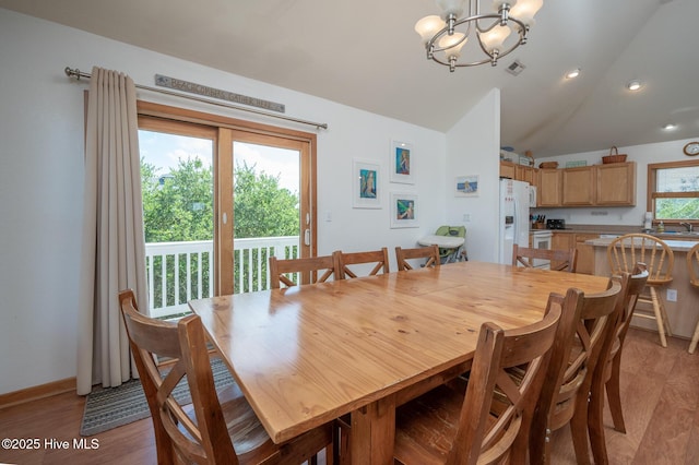 dining area with recessed lighting, a chandelier, vaulted ceiling, and light wood-style floors