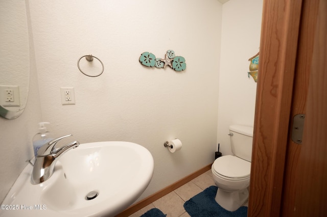 bathroom with baseboards, a sink, tile patterned floors, and toilet