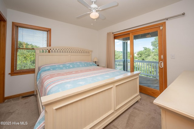 bedroom featuring baseboards, multiple windows, light carpet, and access to exterior