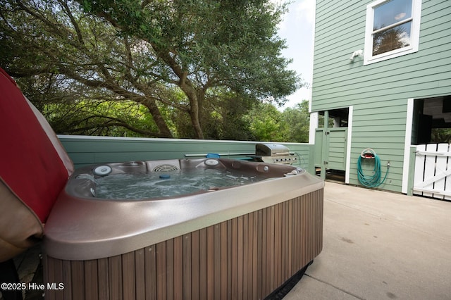 view of patio / terrace featuring a hot tub and a grill