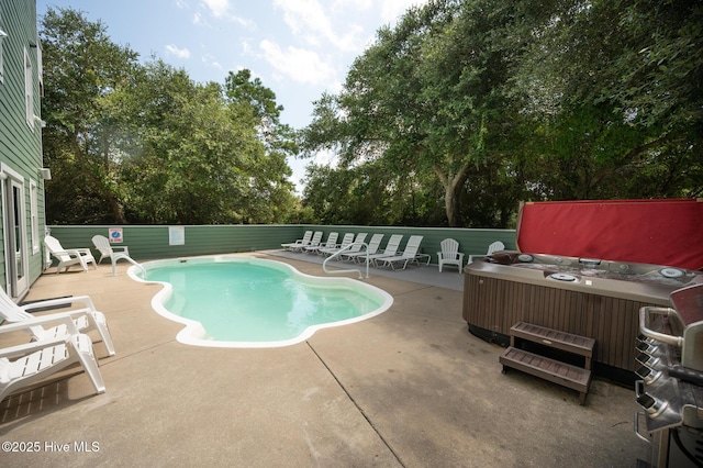 community pool with fence, a patio, and a hot tub
