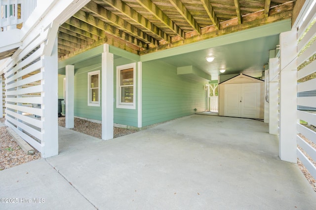 view of patio / terrace featuring an outdoor structure, a carport, and a shed
