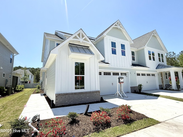 view of front of house with board and batten siding, an attached garage, concrete driveway, and roof with shingles