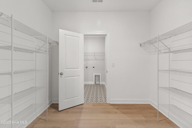 walk in closet featuring light wood-type flooring and visible vents