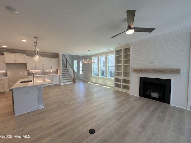 3157 Painted Turtle Loop Unit 37, Wilmington, NC 28409 - unfurnished living room with a chandelier, light wood finished floors, a ceiling fan, a large fireplace, and recessed lighting