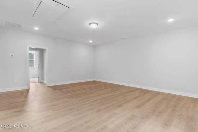 empty room featuring light wood-style floors, attic access, recessed lighting, and visible vents