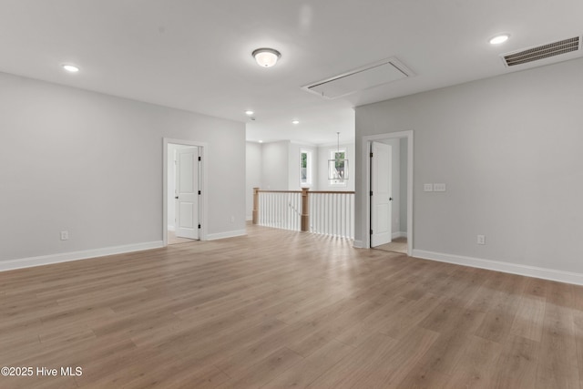 spare room featuring light wood finished floors, attic access, recessed lighting, baseboards, and visible vents