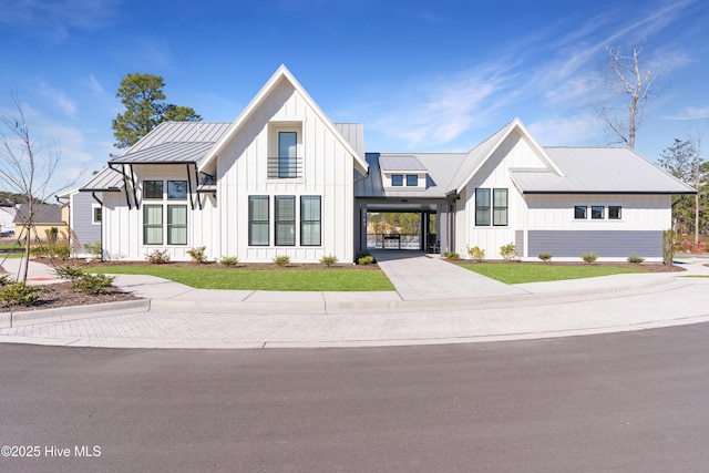 modern farmhouse style home with concrete driveway, board and batten siding, metal roof, and a standing seam roof