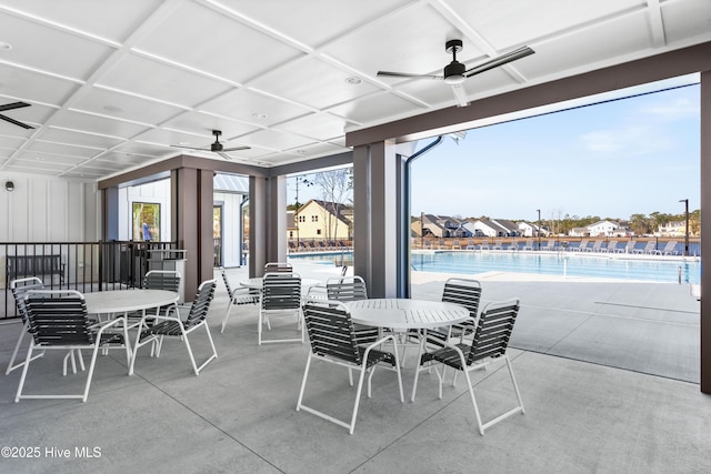 view of patio / terrace featuring a community pool, a ceiling fan, and outdoor dining space