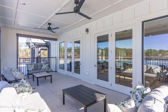 sunroom with a ceiling fan, french doors, and an outdoor hangout area