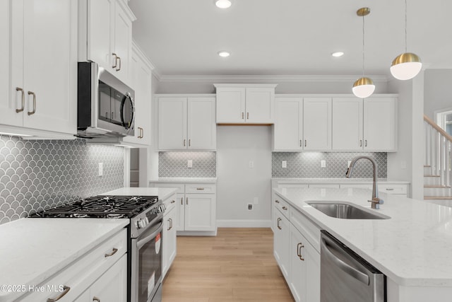 kitchen featuring a sink, appliances with stainless steel finishes, light wood-type flooring, and white cabinetry