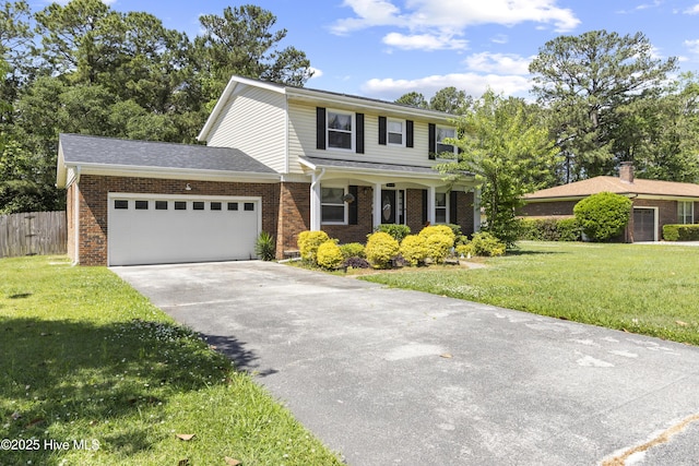 803 Oakwood Ave, Jacksonville, NC 28546 - traditional-style house with an attached garage, a front lawn, fence, and brick siding