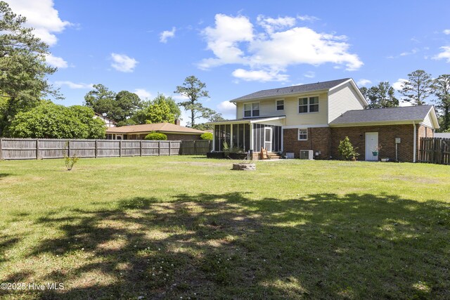 803 Oakwood Ave, Jacksonville, NC 28546 - view of yard featuring a fenced backyard, central air condition unit, and a sunroom