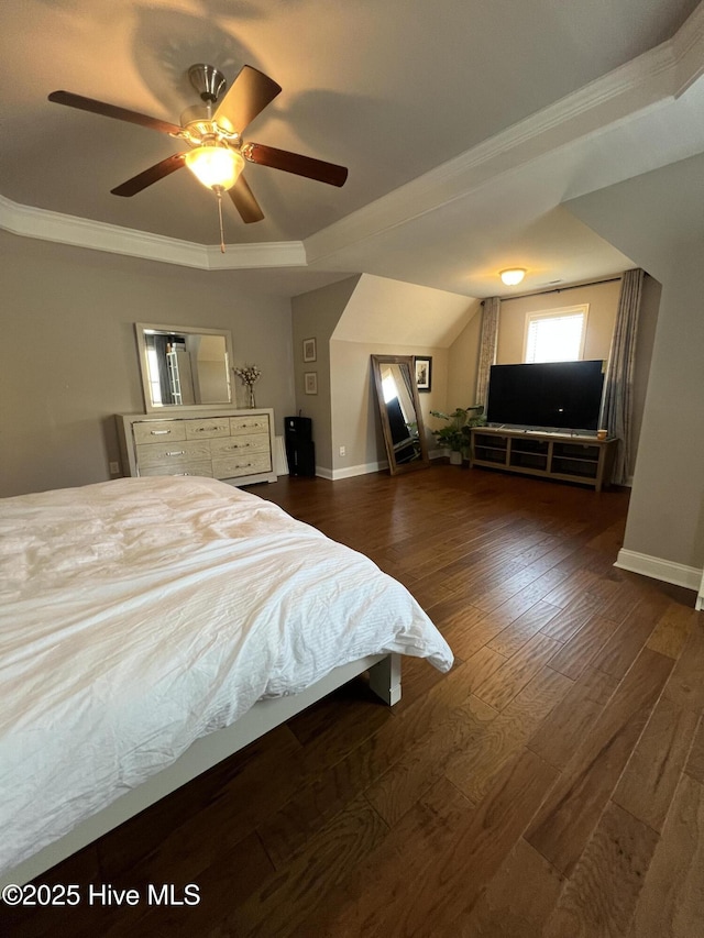 bedroom featuring a raised ceiling, ornamental molding, baseboards, and hardwood / wood-style flooring