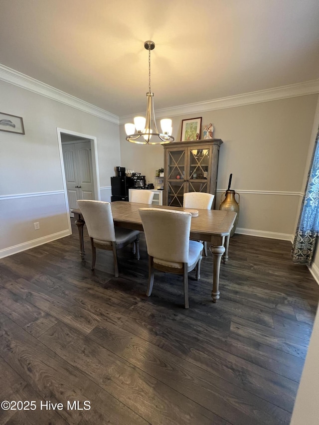 dining room with dark wood-type flooring, ornamental molding, baseboards, and a notable chandelier