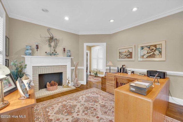 office area with wood finished floors, baseboards, recessed lighting, ornamental molding, and a fireplace
