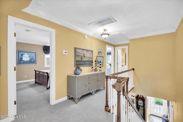 corridor featuring attic access, an upstairs landing, light colored carpet, ornamental molding, and baseboards