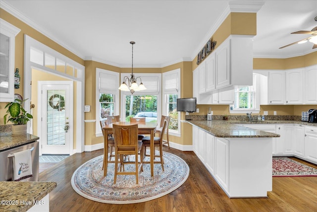 kitchen with white cabinets, dark wood-style floors, glass insert cabinets, dark stone counters, and crown molding