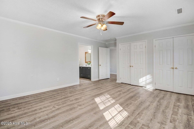 3210 Central Heights Rd, Goldsboro, NC 27534 - unfurnished bedroom with visible vents, ornamental molding, two closets, baseboards, and light wood finished floors