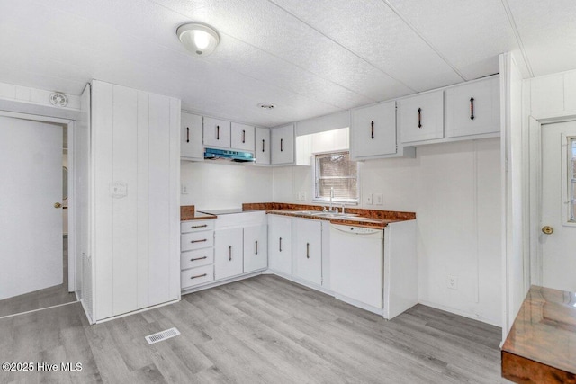 3210 Central Heights Rd, Goldsboro, NC 27534 - kitchen with visible vents, light wood-type flooring, dishwasher, white cabinets, and under cabinet range hood