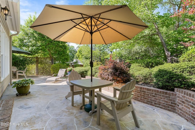 view of patio with outdoor dining area and fence