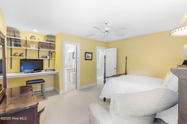 carpeted bedroom with connected bathroom, a ceiling fan, and baseboards