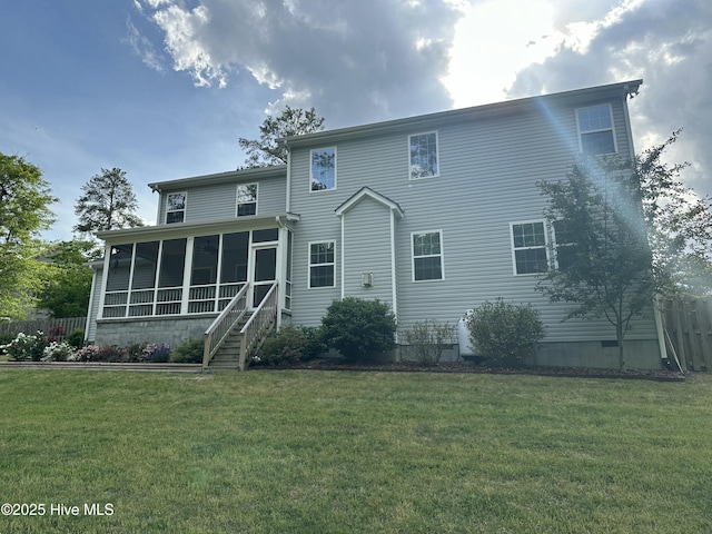 back of property featuring fence, a yard, and a sunroom