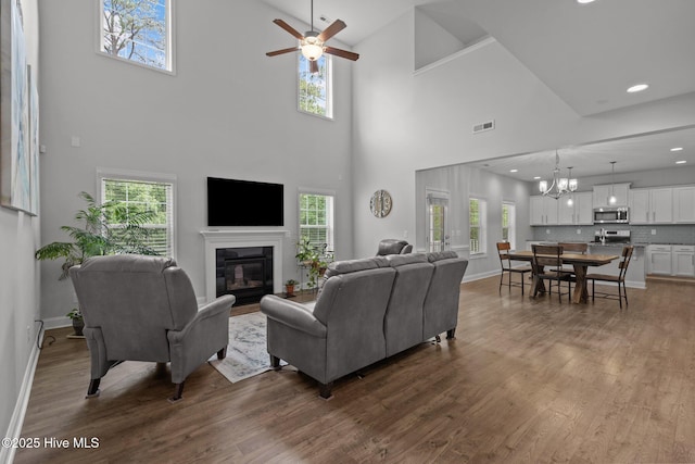 224 Pristine Ct, West End, NC 27376 - living area featuring a glass covered fireplace, dark wood-style floors, a ceiling fan, a chandelier, and recessed lighting