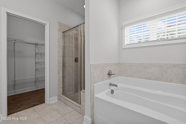 224 Pristine Ct, West End, NC 27376 - bathroom featuring a shower stall, a spacious closet, tile patterned floors, and a garden tub