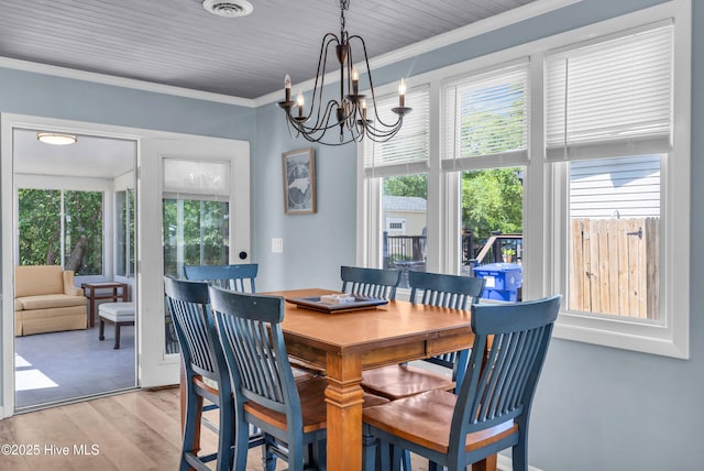 2005 E Oak Island Dr, Oak Island, NC 28465 - dining space with an inviting chandelier, crown molding, light wood-style floors, and visible vents