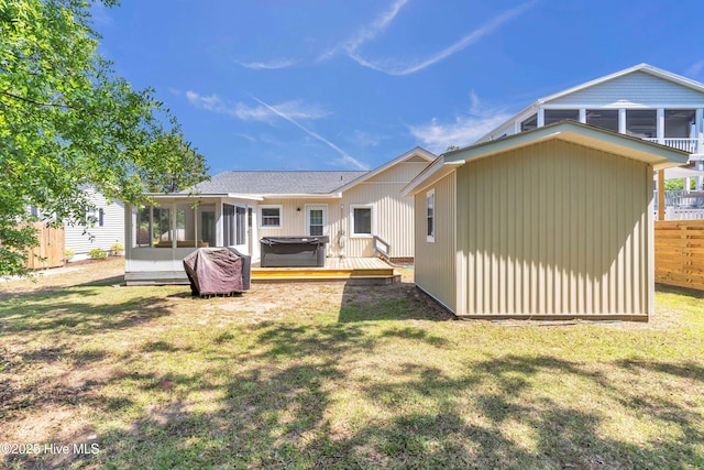 2005 E Oak Island Dr, Oak Island, NC 28465 - back of house featuring a hot tub, a yard, and a sunroom