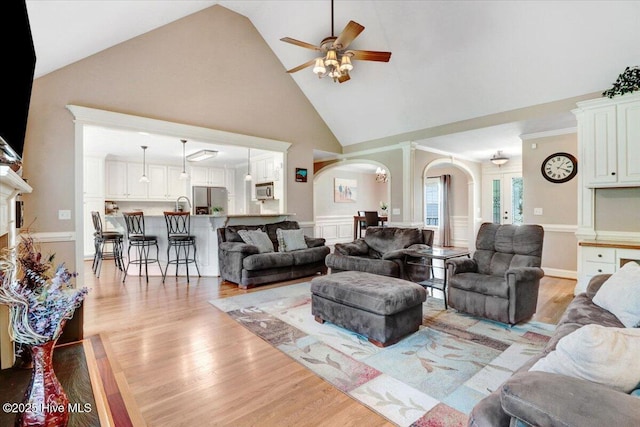 1171 Airport Rd, Pikeville, NC 27863 - living area featuring light wood-type flooring, a ceiling fan, arched walkways, and high vaulted ceiling