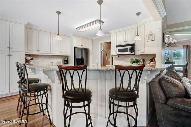 1171 Airport Rd, Pikeville, NC 27863 - kitchen featuring freestanding refrigerator, decorative backsplash, a peninsula, white microwave, and white cabinets