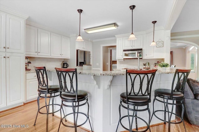 1171 Airport Rd, Pikeville, NC 27863 - kitchen with white cabinets, stainless steel fridge with ice dispenser, light wood-type flooring, backsplash, and ornamental molding