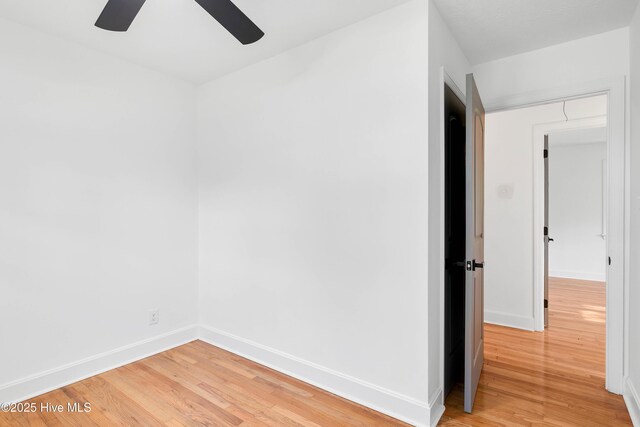 empty room with baseboards, ceiling fan, and light wood finished floors