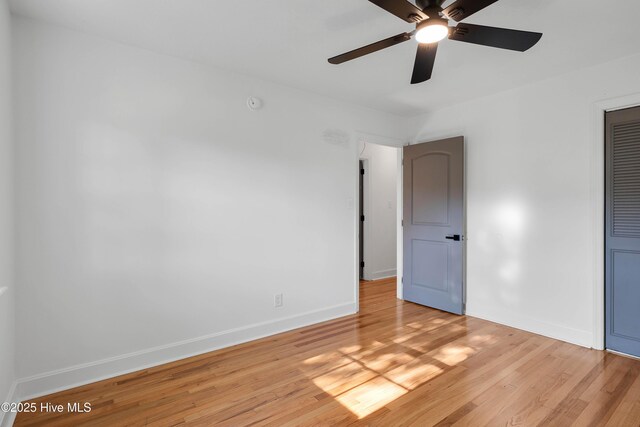 spare room featuring ceiling fan, baseboards, and light wood-type flooring
