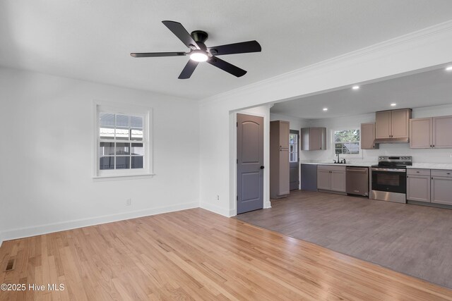 kitchen featuring light countertops, gray cabinets, a ceiling fan, light wood-style flooring, and appliances with stainless steel finishes